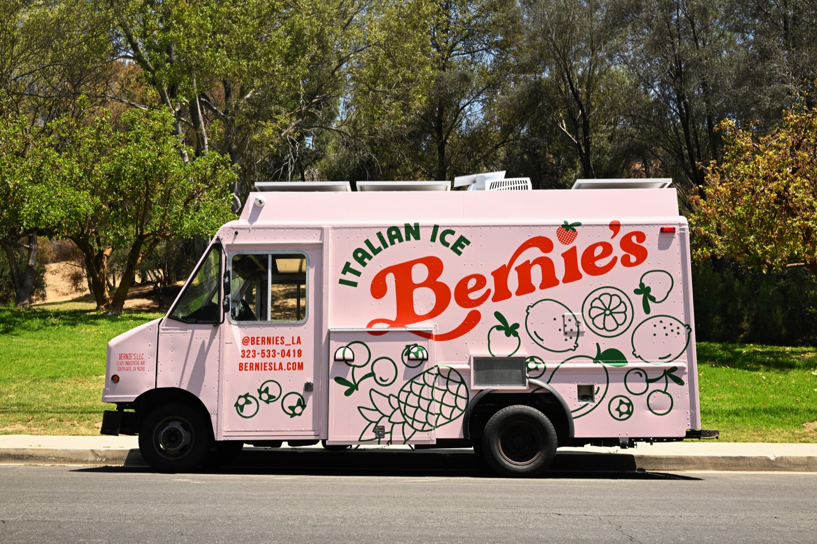 The pink Bernie&rsquo;s Italian Ice dessert food truck parked streetside in Los Angeles, decorated with green fruit line art