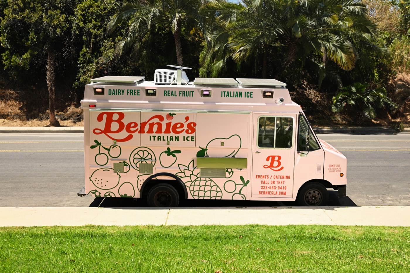 Side view of the pink Bernie’s dessert food truck with Italian Ice lettering and fruit line art